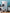 Collection of kitchen appliances including a refrigerator, microwave, and blender against a blue wall.