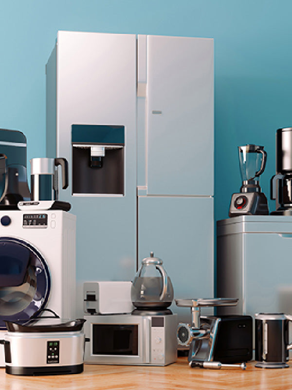 Collection of kitchen appliances including a refrigerator, microwave, and blender against a blue wall.
