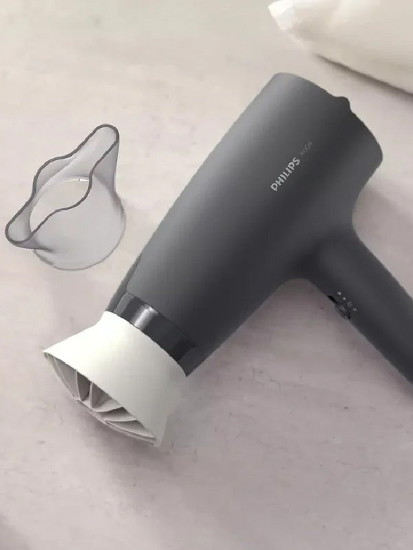 Philips hair dryer with a nozzle attachment on a light gray surface