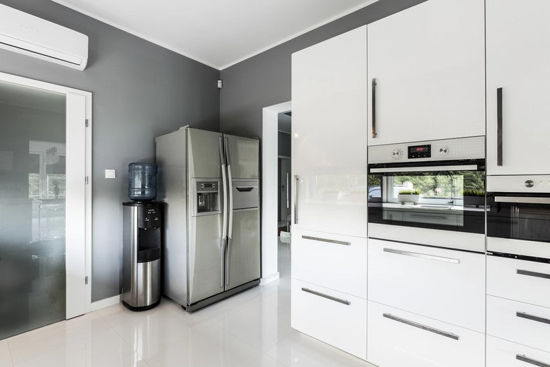 Modern kitchen with stainless steel appliances and white cabinets.